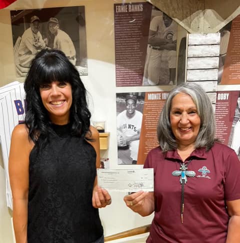 Anita Peters, member of the Mesa Hohokams, delivers a grant to Susan Ricci from the Mesa Historical museum.