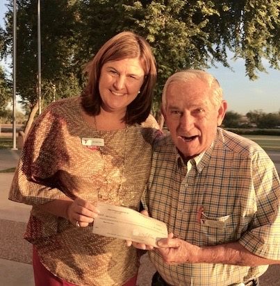 HoHoKam, Craig Cummins, presents a grant check from the HoHoKam Foundation to Katie Smetana of the Mesa Family YMCA