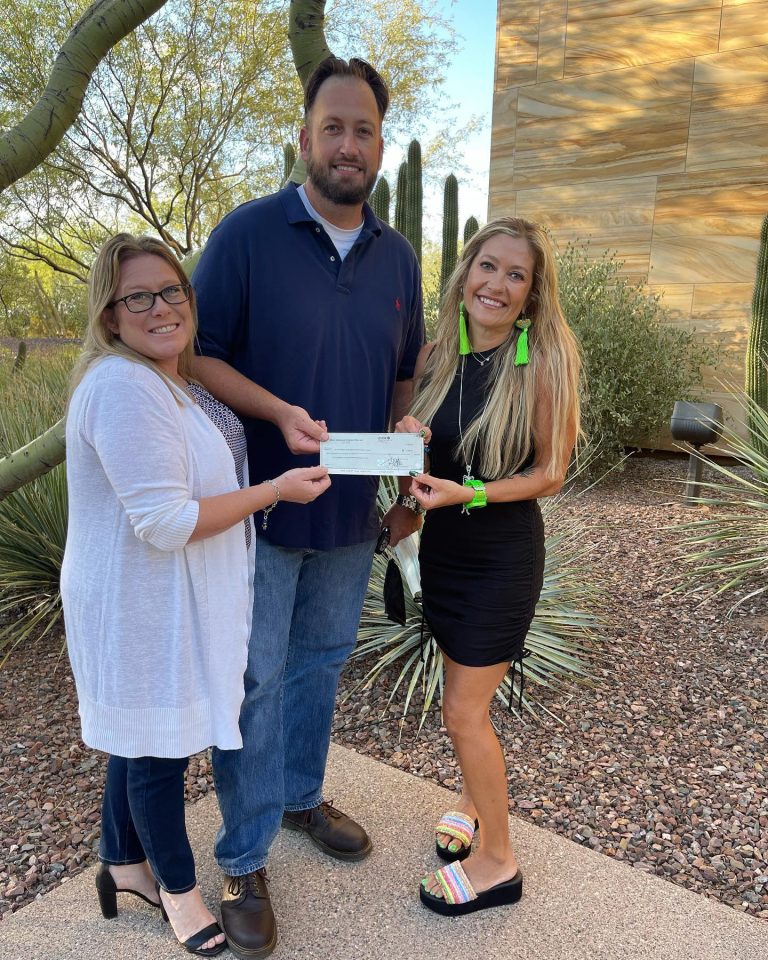 HoHoKam, Stephanie Siete, presents a check to Christina and Bobby, from the Arizona Knowledge Empowerment and Advocacy Group.