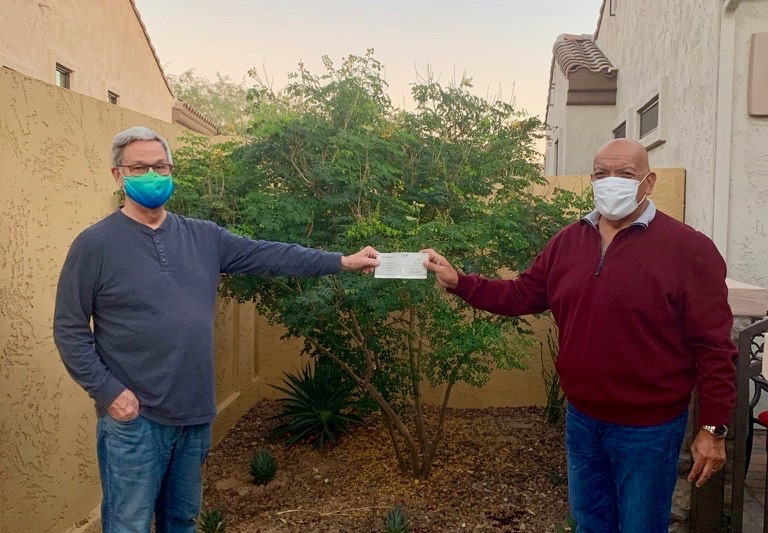 Mesa HoHoKam , Bob White, presents a check, from the Mesa HoHoKam Foundation, (with proper social distancing & PPE), to Ray Villa, CEO of the Community Alliance Against Family Abuse. (CAAFA)