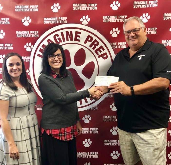 On behalf of Mesa HoHoKam Member, George F. Bliss, Mara Benson presents a check, from the Mesa HoHoKam Foundation, to Lou Stirpe with the Athletic Department at Imagine Prep