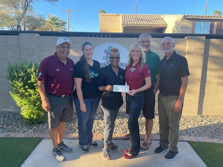 Mesa HoHoKam Shanlyn Newman presents a Grant check from the 50/50 Cubs/HoHoKam raffle to Jaun Te Dailey, President and Executive Director of DSquared Homes For The Homeless, also Pamela Leslie, Homeless Outreach Manager.