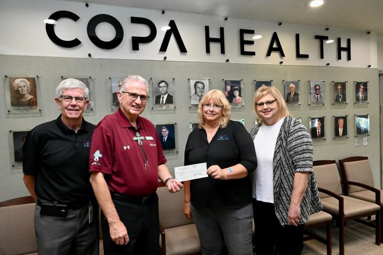 Hohokam member Chris Schneck presents a 50/50 raffle check to Copa Health.