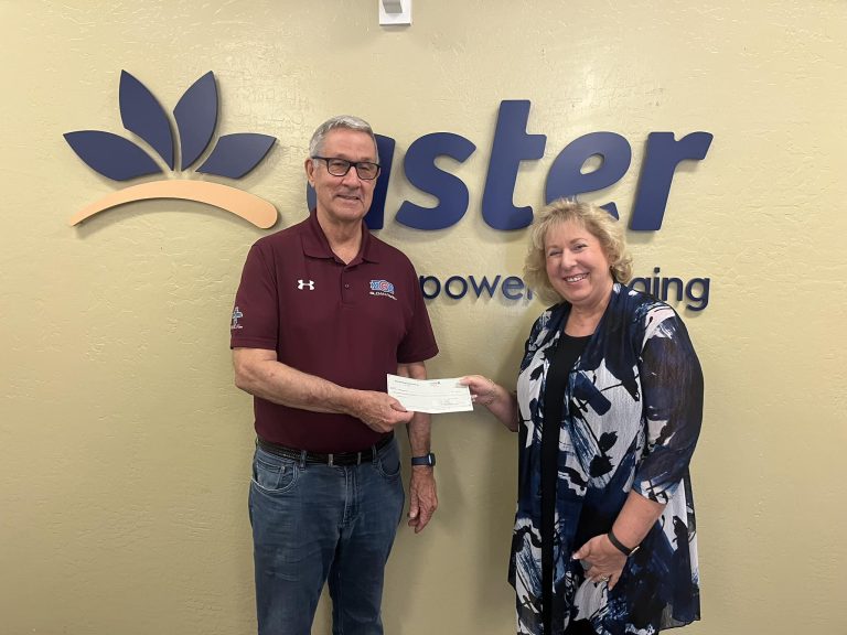 Aster Aging CEO Deborah Schaus receives a 50/50 Raffle Grant award check from the Mesa HoHokam member, Bob White.